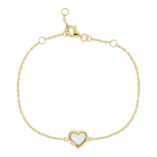 Armband aus goldfarbenem Metall mit herzförmigem Anhänger aus Muttermilch-Kunstharz und einem kleinen Stein.