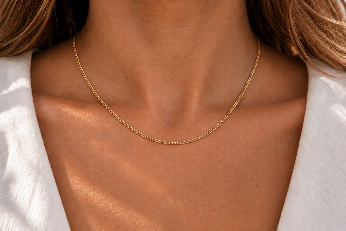 Feine Kette aus glänzendem Gelbgold mit zarten Gliedern, die sanft am Hals liegt.